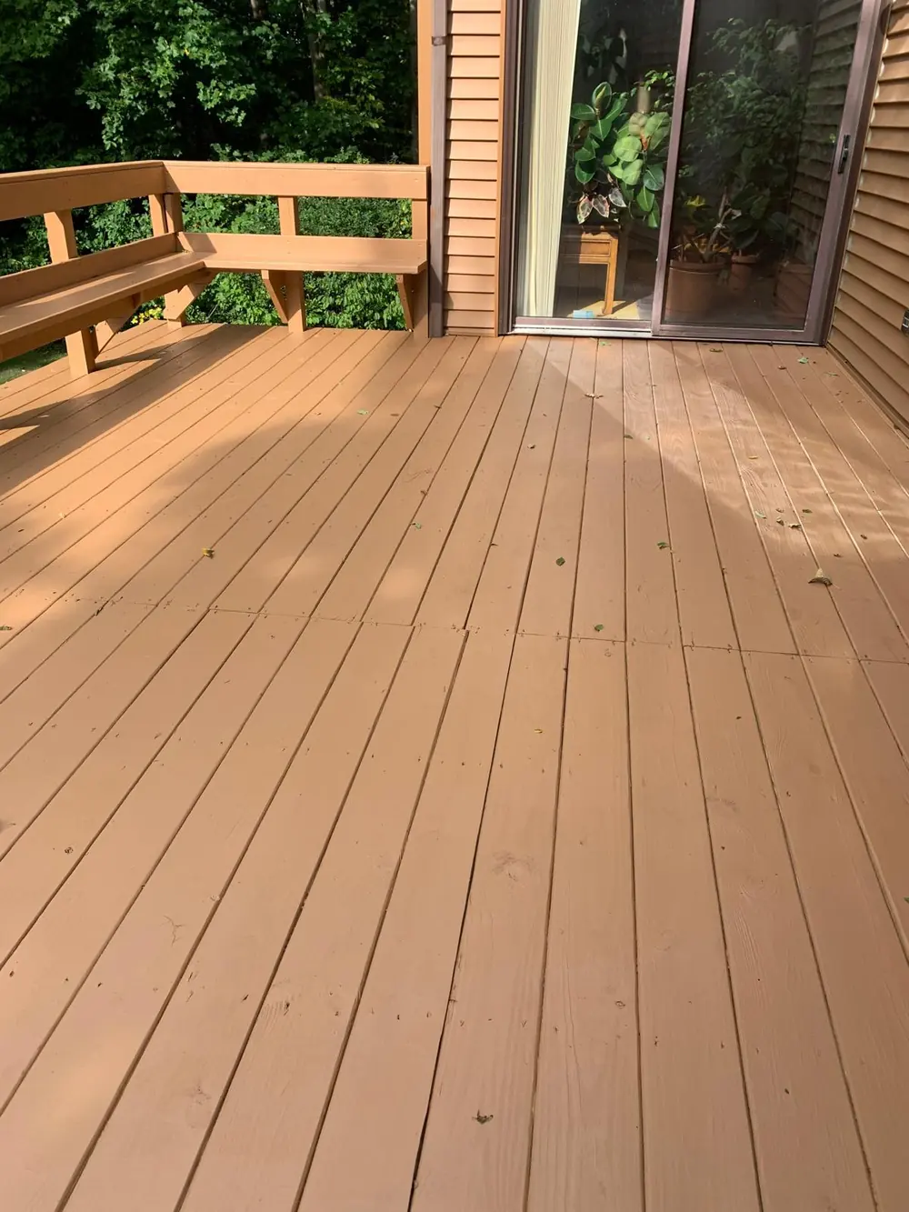 Stained composite deck with a built-in corner bench in Buffalo, NY