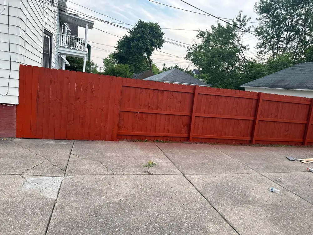 Tall red-stained privacy fence in the backyard in Buffalo, NY
