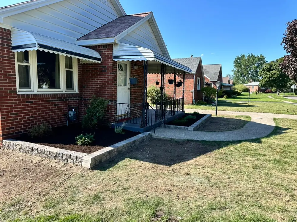 New stone-edged garden bed freshly planted in Buffalo, NY