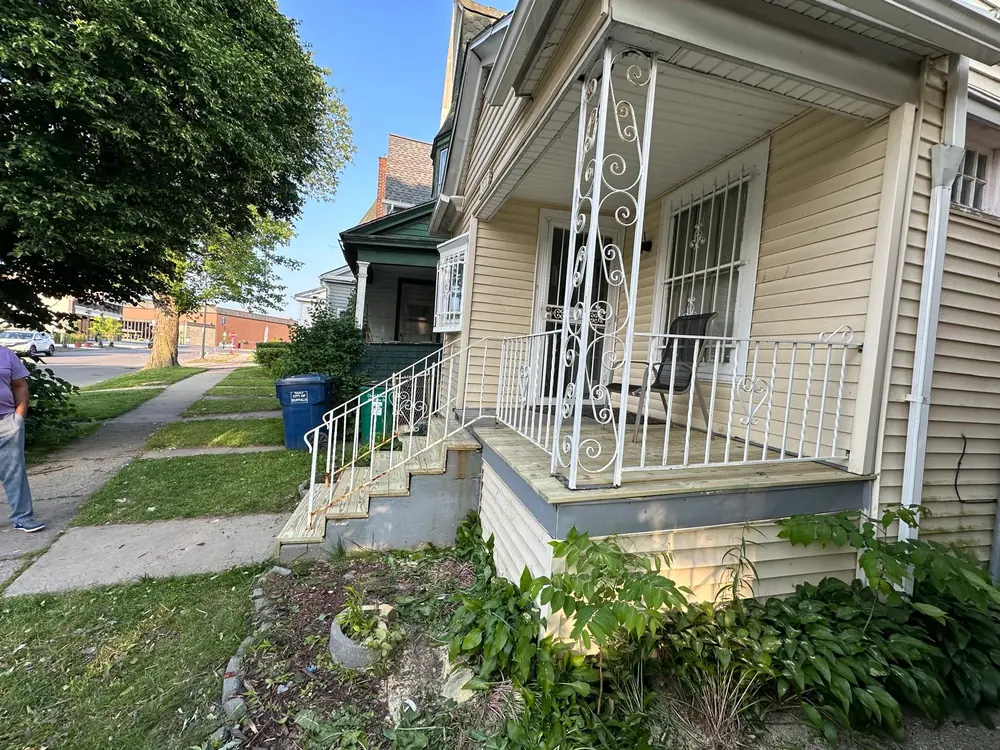Covered porch with ornate white ironwork railing in Buffalo, NY