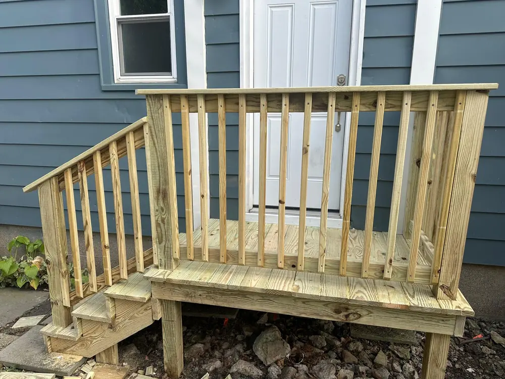 New pressure-treated wood railing on a back porch in Buffalo, NY