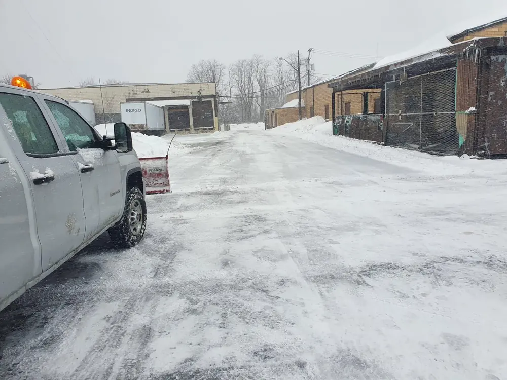 Plow truck clearing a commercial loading dock in Buffalo, NY