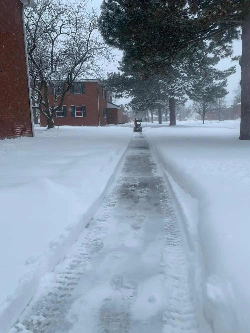 Snowblowing a sidewalk during heavy snowfall in Buffalo, NY